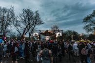 在多云的天空下，充满活力的人群聚集在一起，参加户外音乐节