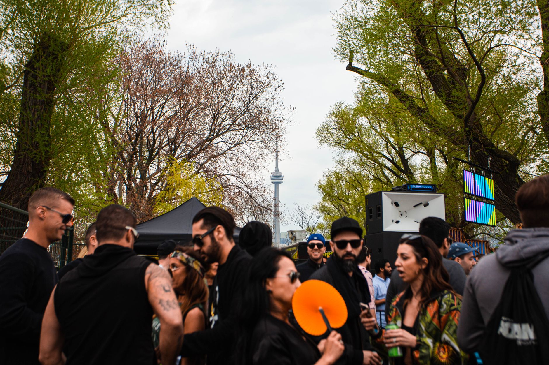 Vibrant outdoor group gathering near CN Tower in Toronto, daytime setting.