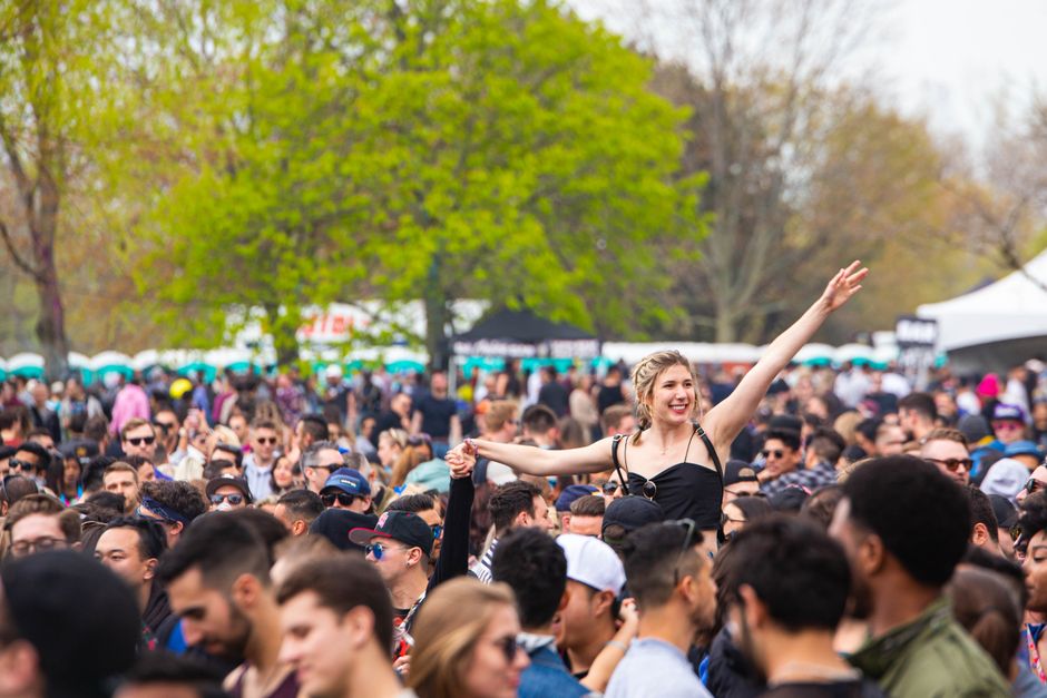 A lively outdoor music festival with diverse crowd enjoying the sunny day.