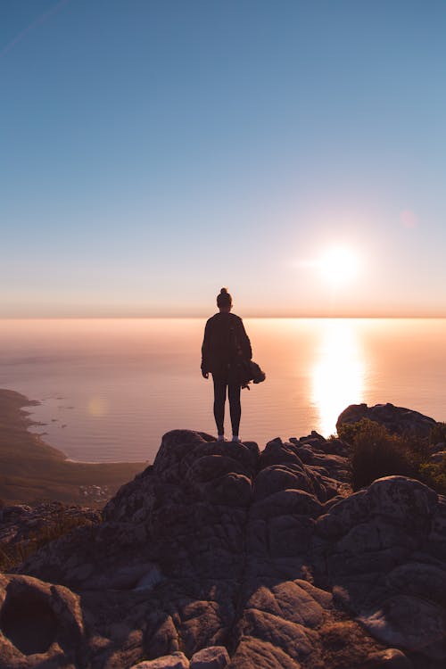 Free Person Standing on Brown Rock Formation Stock Photo