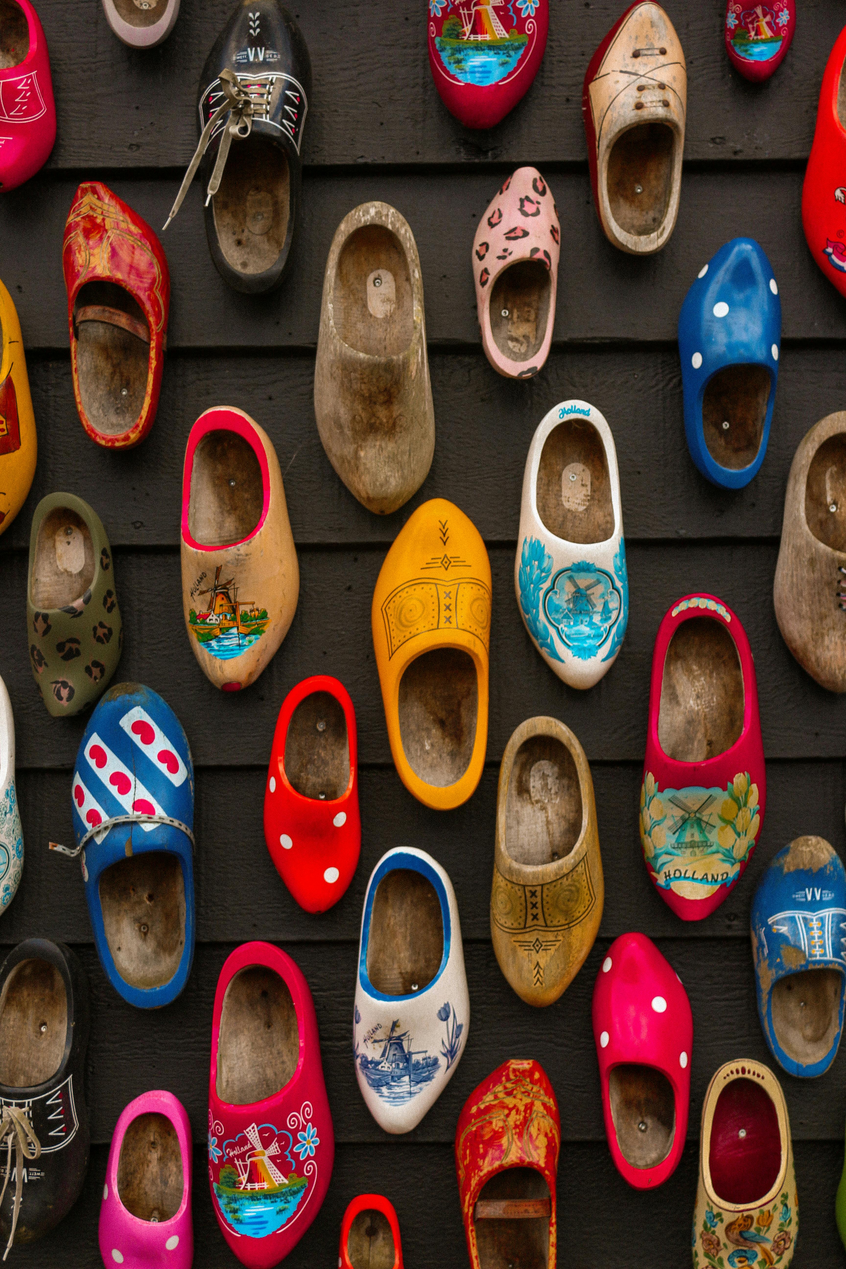 Vibrant array of traditional Dutch wooden shoes displayed on a wall.