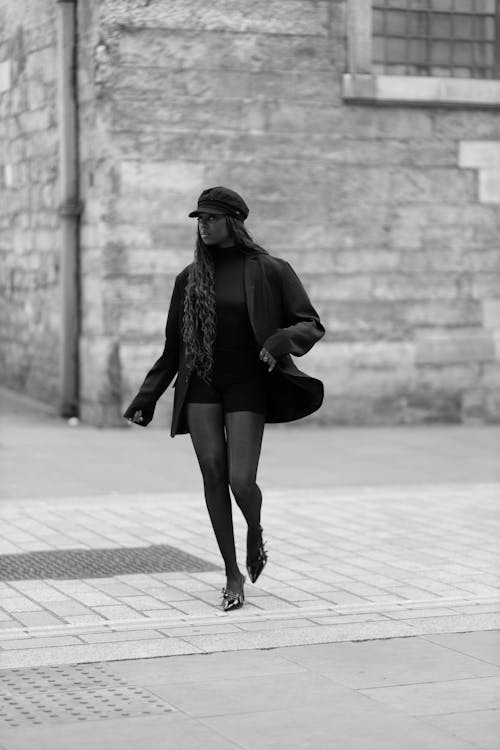 A woman in black and white walking down the street