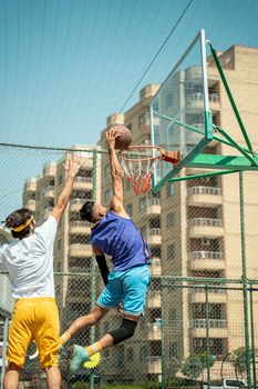 Dynamic basketball scene with players in action on an urban court in Baghdad.