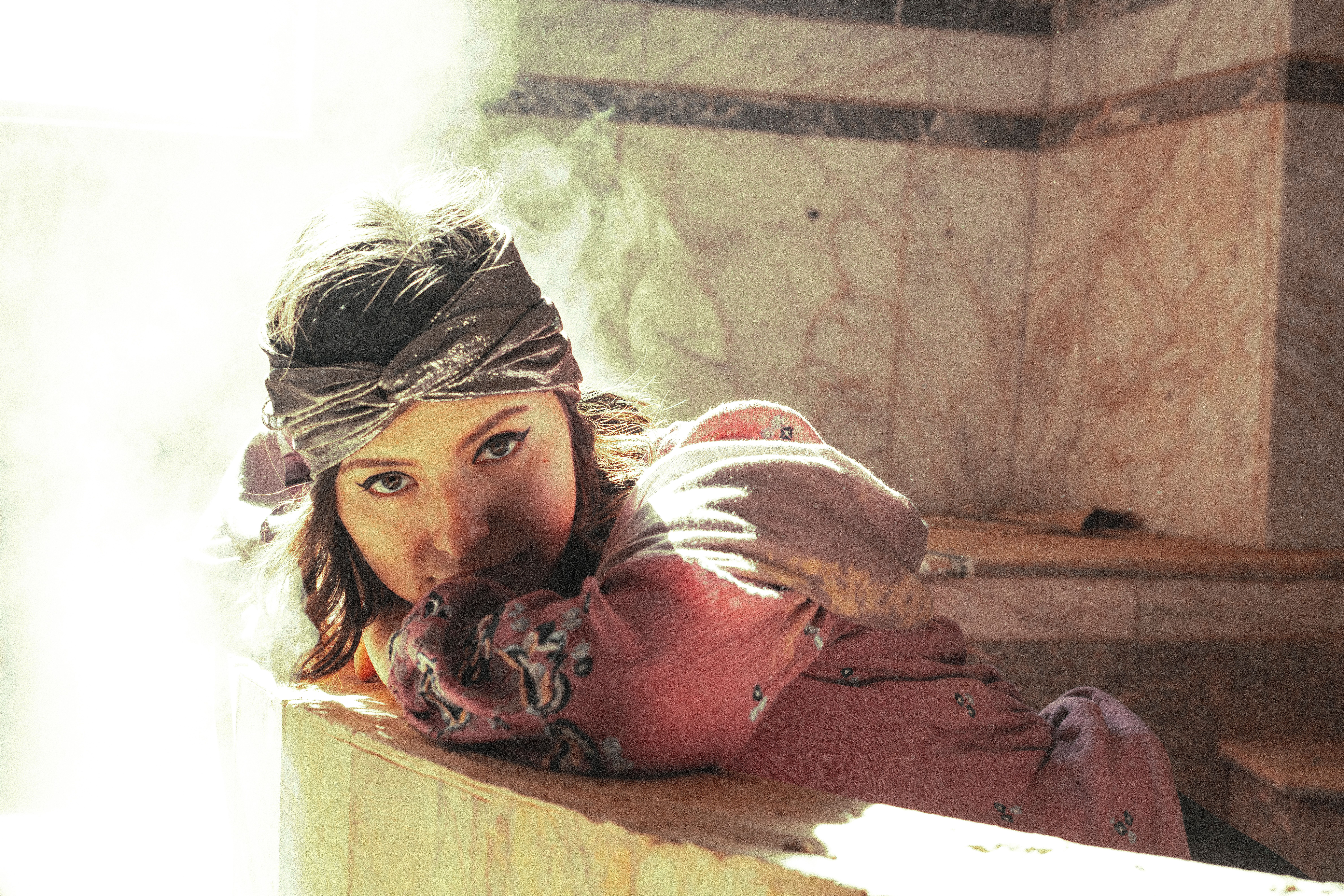 A woman relaxes in a hammam, bathed in ethereal light, creating a serene atmosphere.