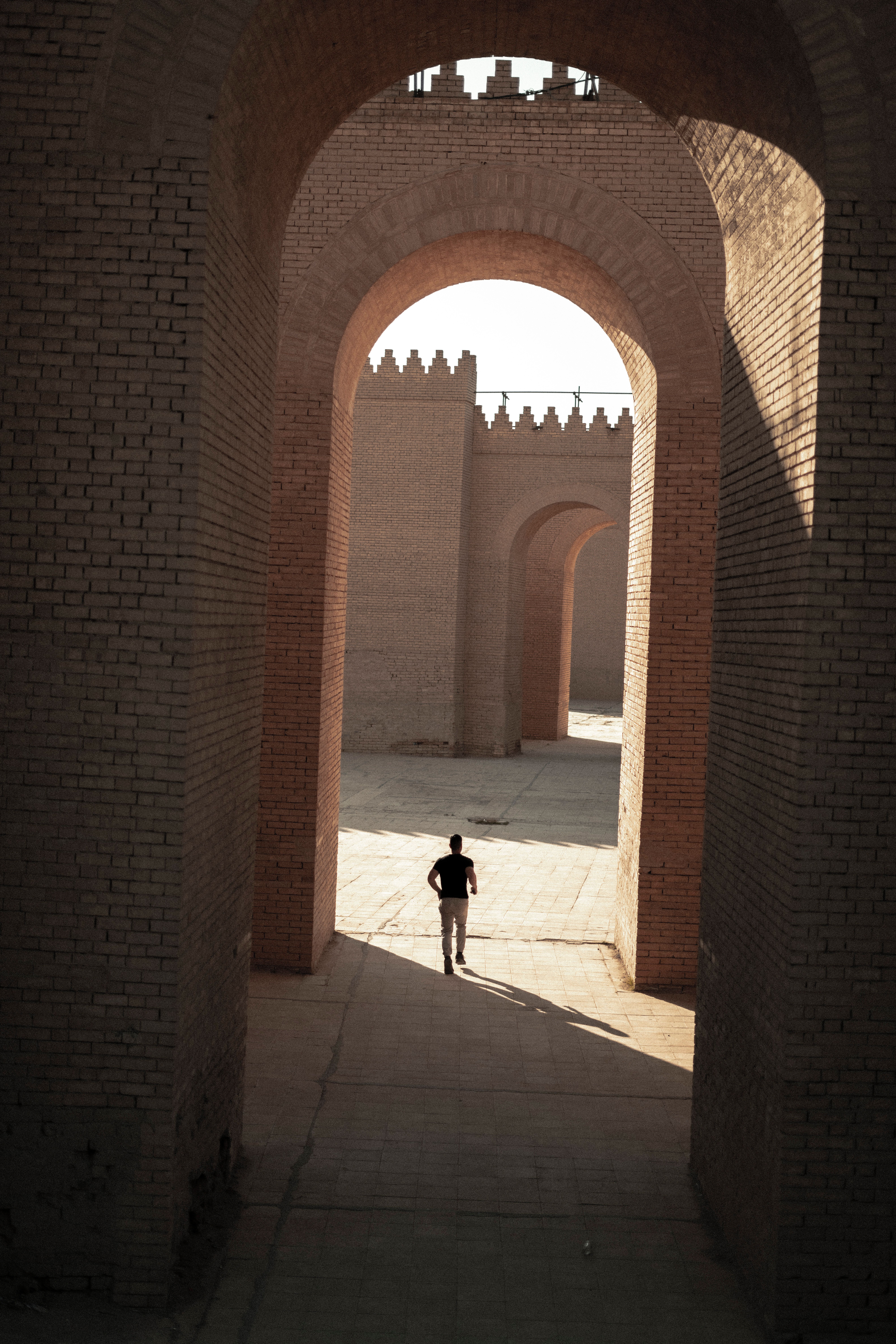 Un visitatore cammina tra le mura in mattoni dell'antica Babilonia, vicino a Hilla, in Iraq