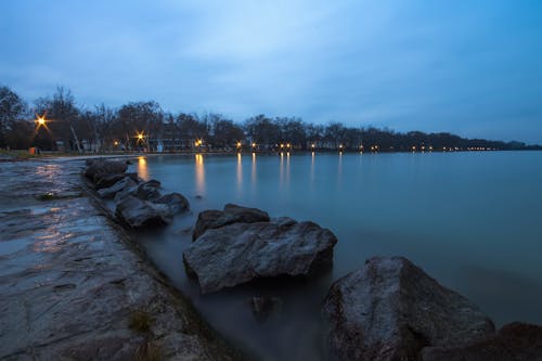 Large Rocks in Bay Under White and Blue Cloudy Sky