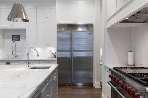 Free Stainless Steel Refrigerator Beside White Kitchen Cabinet Stock Photo