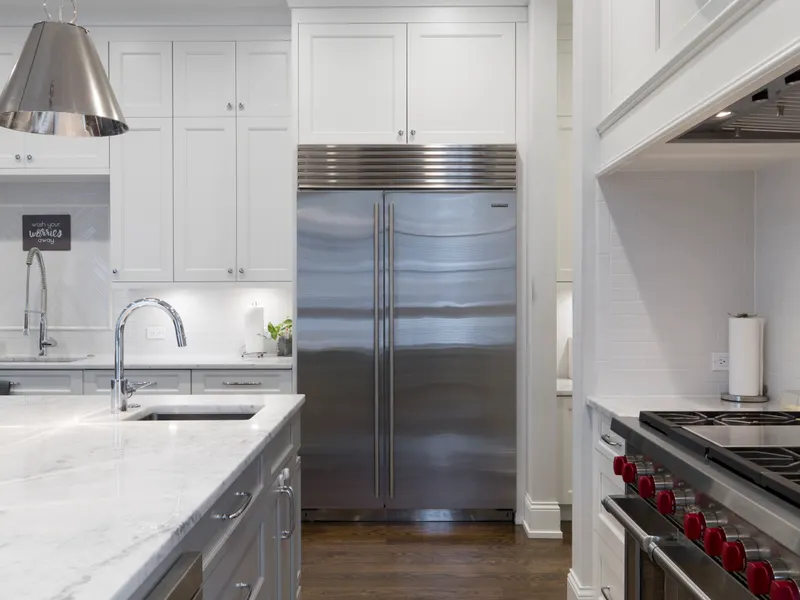Refrigerator repair across San Diego County Stainless steel refrigerator beside a white kitchen cabinet