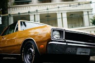 一辆经典的20世纪70年代道奇汽车停在城市环境中，闪亮的镀铬细节凸显了其复古设计