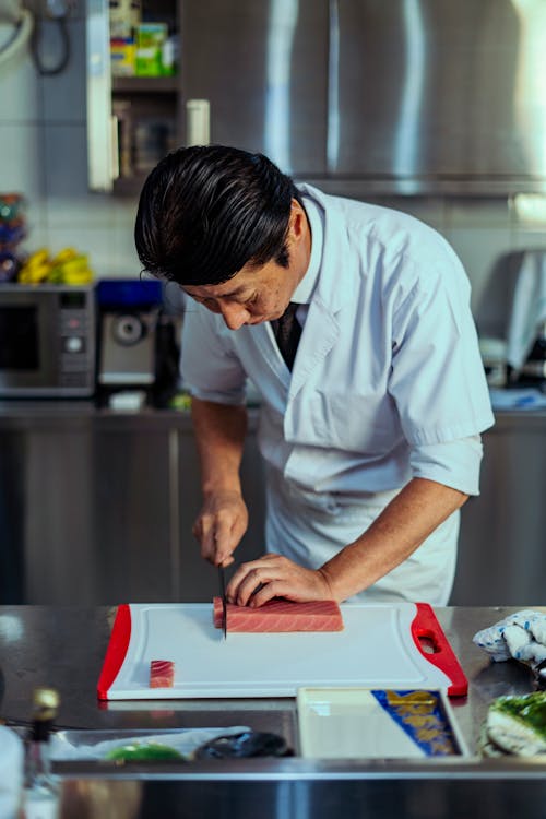 Cook Cutting Meat in Kitchen