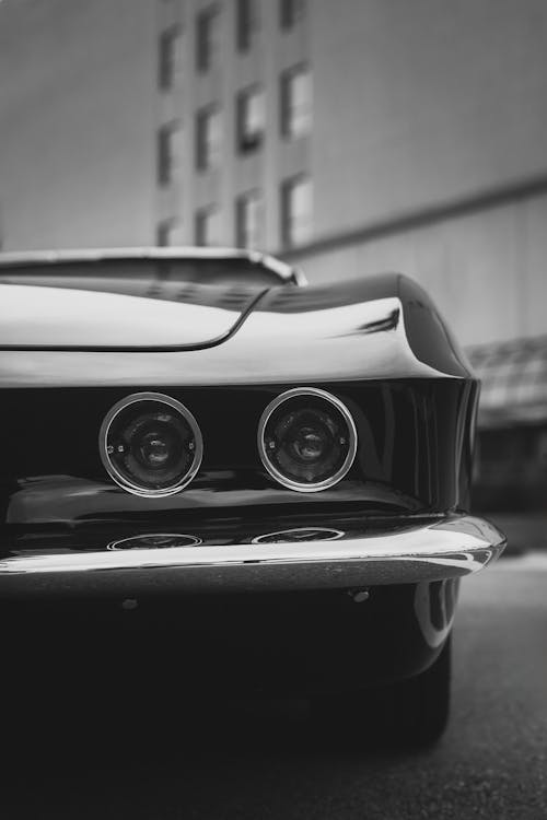 Black and white photo of a car with a black and white background