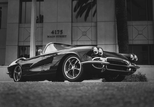 Free Black and white image of a classic convertible parked in the city. Stock Photo