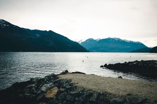 Peaceful scene of a lake with mountains in Vancouver, BC. Ideal for nature lovers and adventurers.