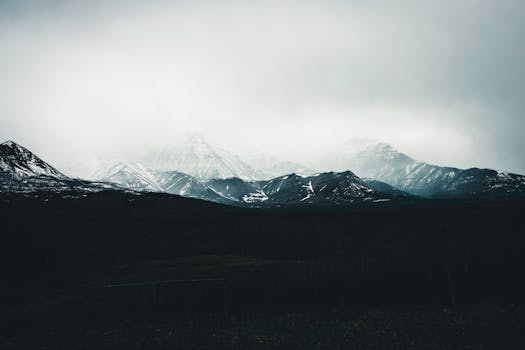Atmospheric view of snow-capped mountains shrouded in mist at Waterton Park, Alberta, Canada.