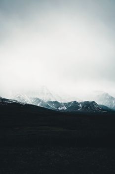 Gloomy winter view of misty mountains in Waterton Park, Alberta, Canada.