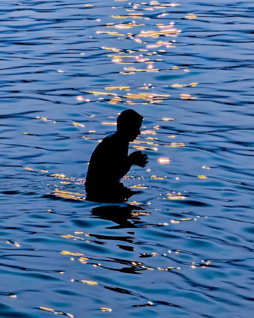 A silhouette of a person in the water