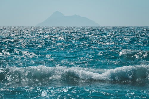 A view of the ocean with a mountain in the background