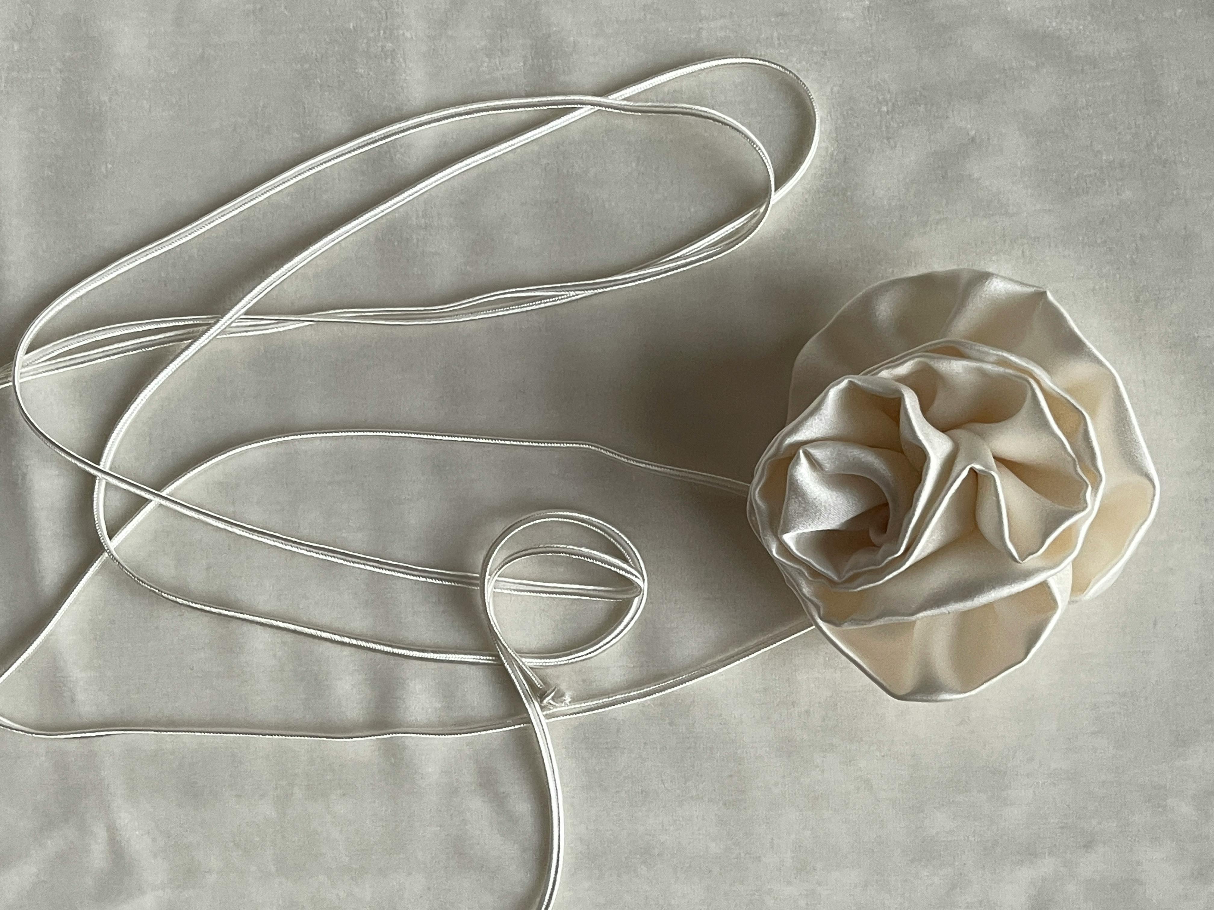 Elegant white silk fabric with an artistic string arrangement on a seamless white background. Ideal for textile projects.