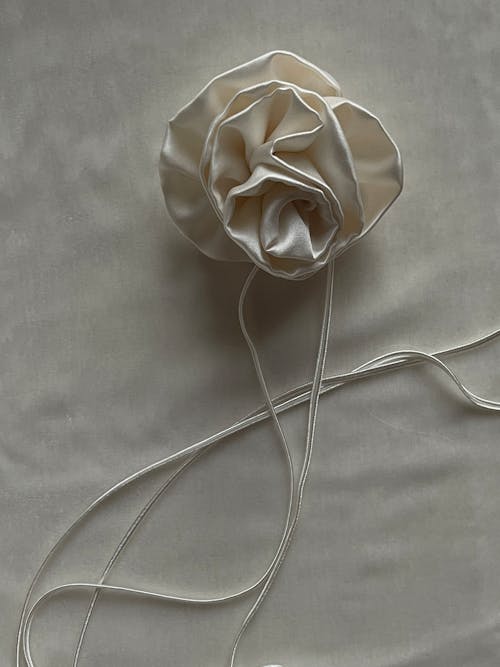 A white rose is tied to a string