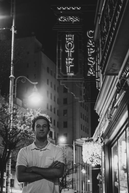 A man standing in front of a hotel sign