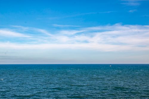 Free A serene view of the ocean meeting a clear blue sky, capturing tranquility and nature's beauty. Stock Photo