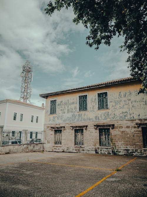 An old building with graffiti on it and a tree in the background