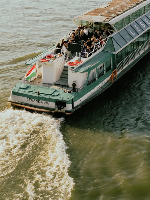 A boat traveling on the river with people on it