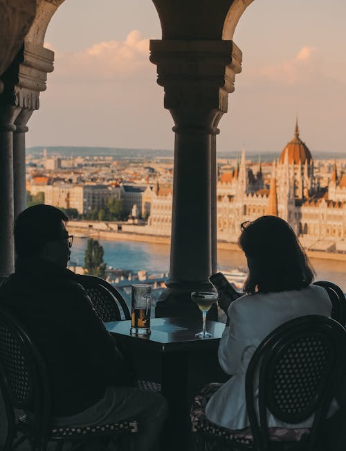 Two people sitting at a table with a view of the budapest castle