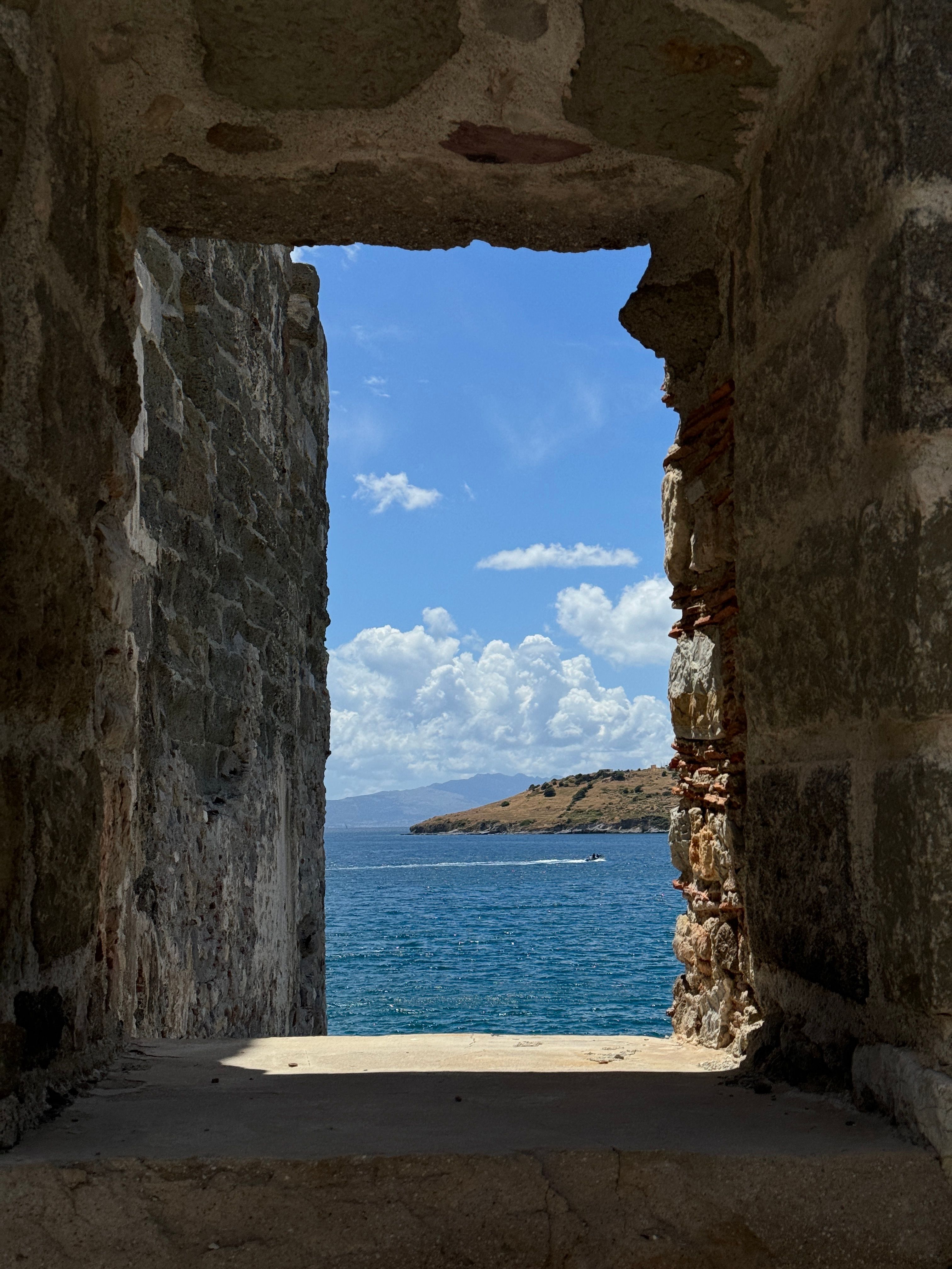 Sea Shore behind Window Opening in Stone Wall · Free Stock Photo
