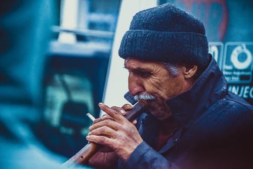 Person Holding Brown Smoking Pipe