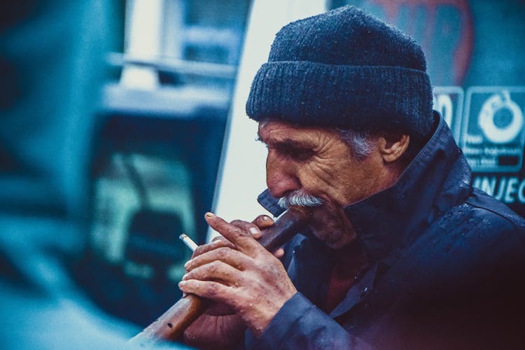 Person Holding Brown Smoking Pipe