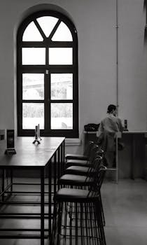 Stylish black and white photograph of a cafe interior with a woman sitting by the window in İstanbul.