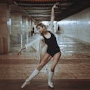 一位优雅的芭蕾舞演员在充满戏剧性的城市走廊里摆出姿势，展现她的优雅