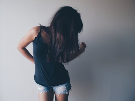 Artistic shot of a woman in casual fashion, showcasing motion and style.