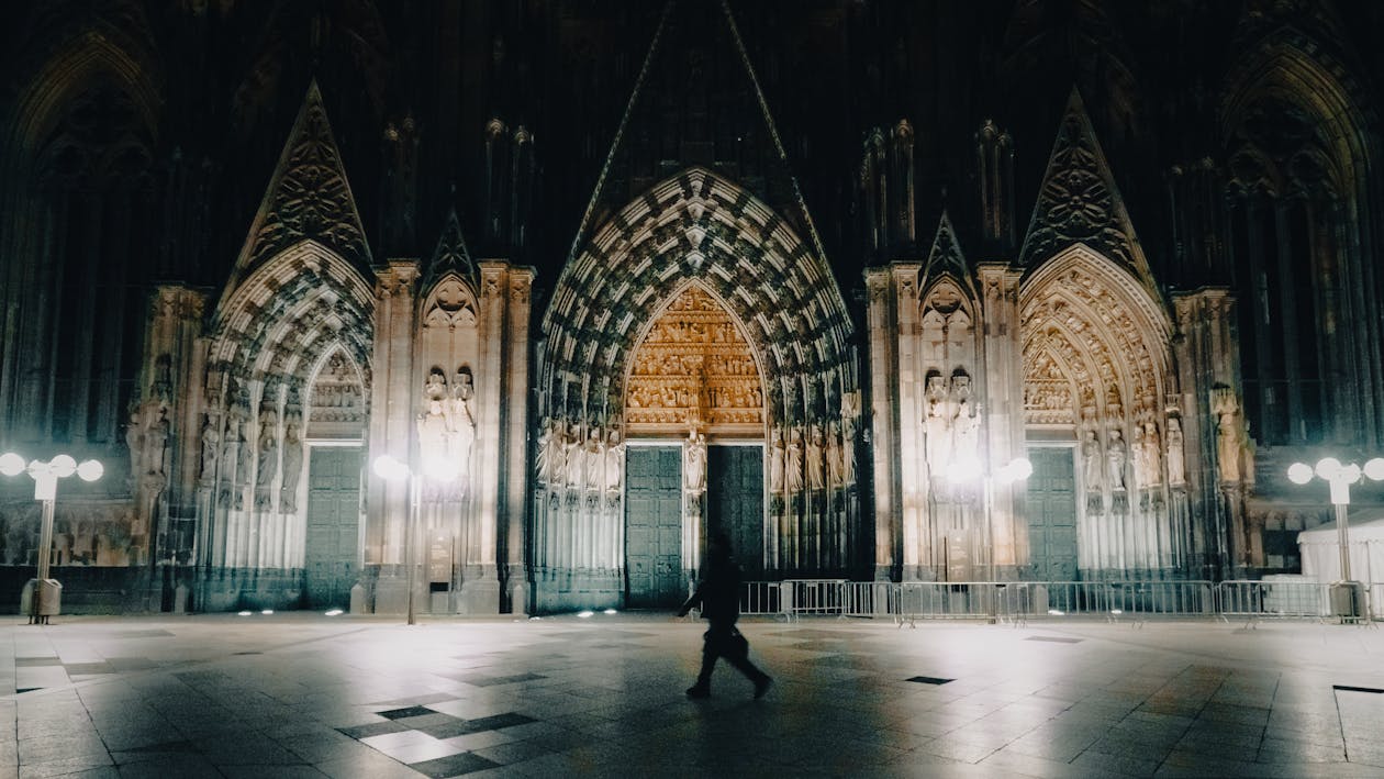 A person walking through a cathedral at night