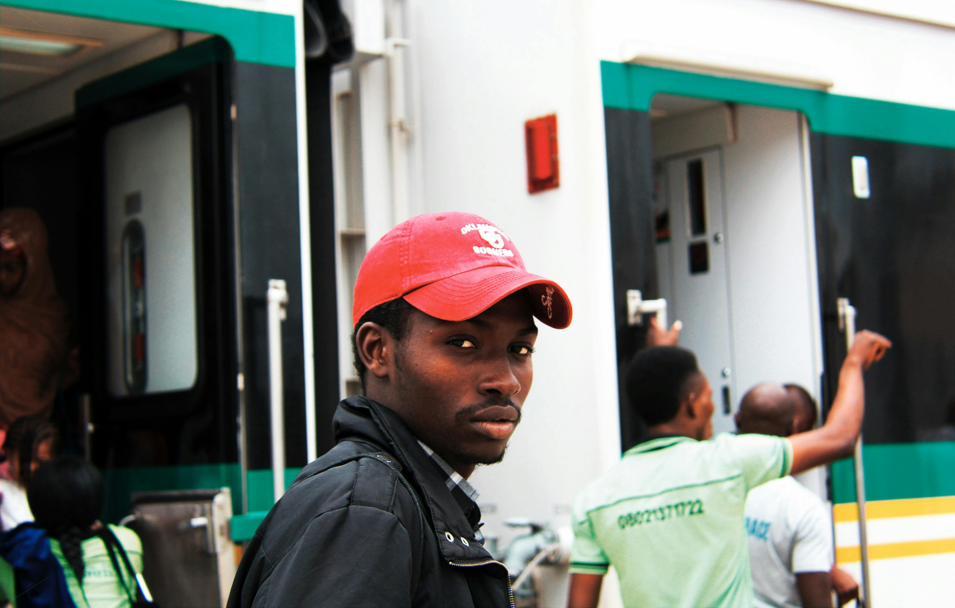 Man Wearing Baseball Cap Standing Near Train · Free Stock Photo