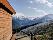 A wooden cabin overlooking the mountains and snow