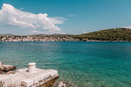 Free Scenic view of a tranquil coastal town with vibrant blue water and lush greenery, perfect for travel and relaxation. Stock Photo