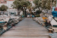 在一个风景如画的沿海小镇，宁静的木码头上停靠着帆船和游艇