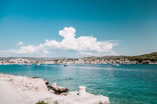 Free Beautiful view of the Croatian coastline with clear blue water and a charming town in the background. Stock Photo