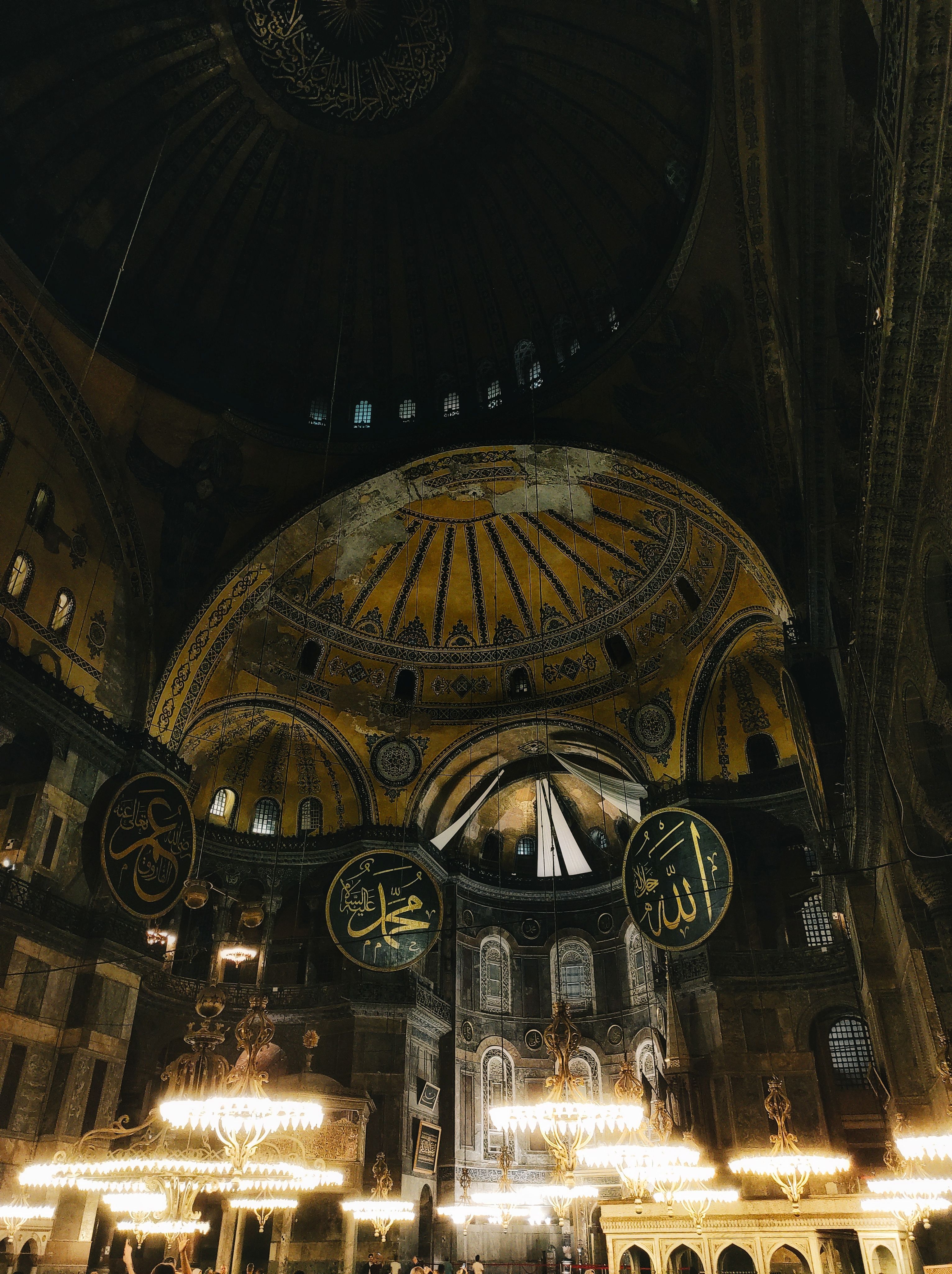 Majestic interior of Hagia Sophia with intricate Islamic calligraphy and architecture.