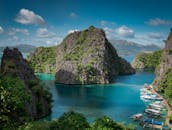 科伦岛的碧绿海水、岩石结构和船只，构成了一幅壮丽的景色