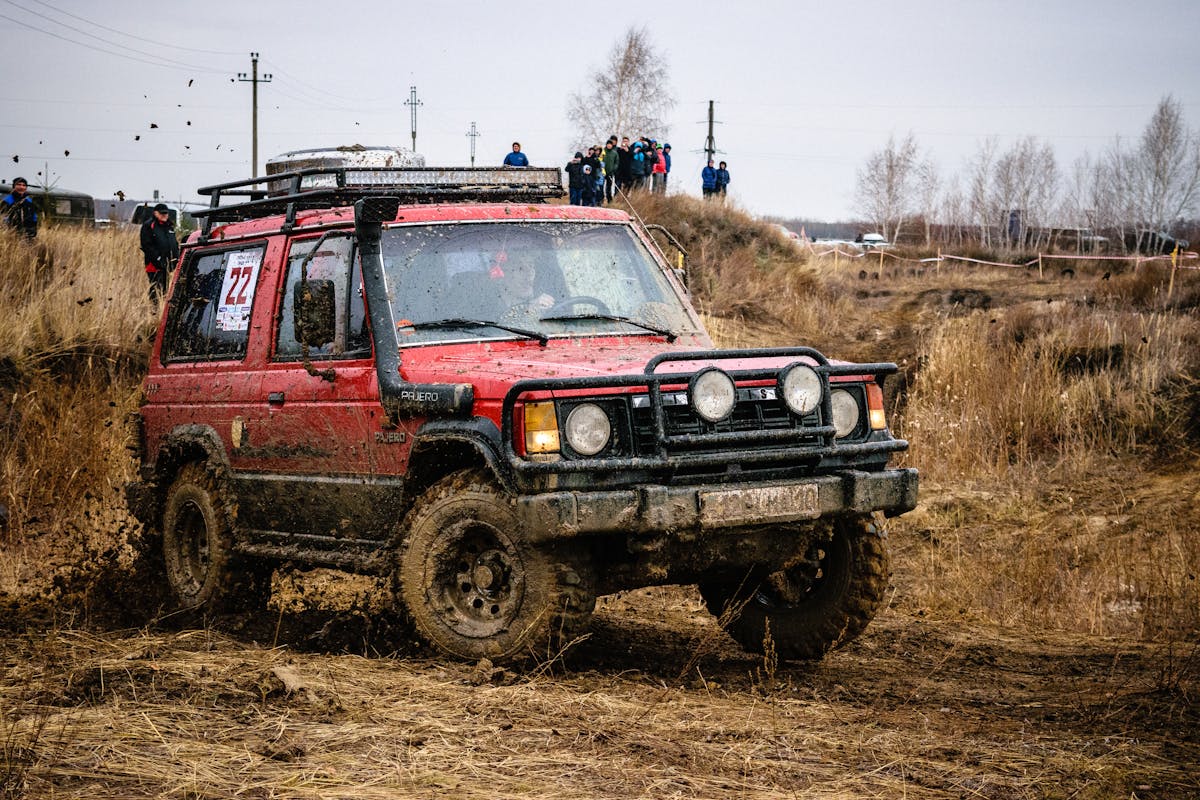 Red SUV on a muddy off-road track