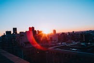 纽约市天际线上，戏剧性的日落被充满活力的镜头耀斑所凸显，映照着建筑物