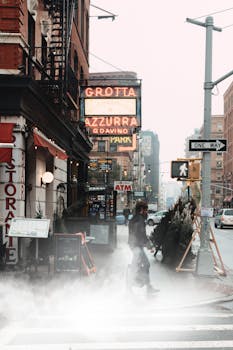 一名男子穿过纽约市一条雾气弥漫的街道，两旁林立着城市建筑和标志