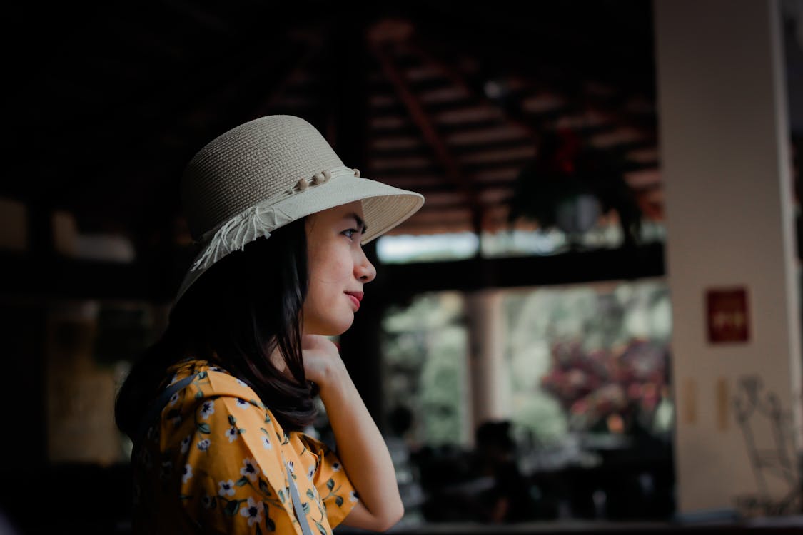 Free Side View Photo of Woman in Sun Hat Looking Out Stock Photo