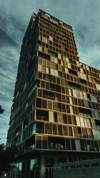 Contemporary high-rise building with a unique facade viewed at sunset.