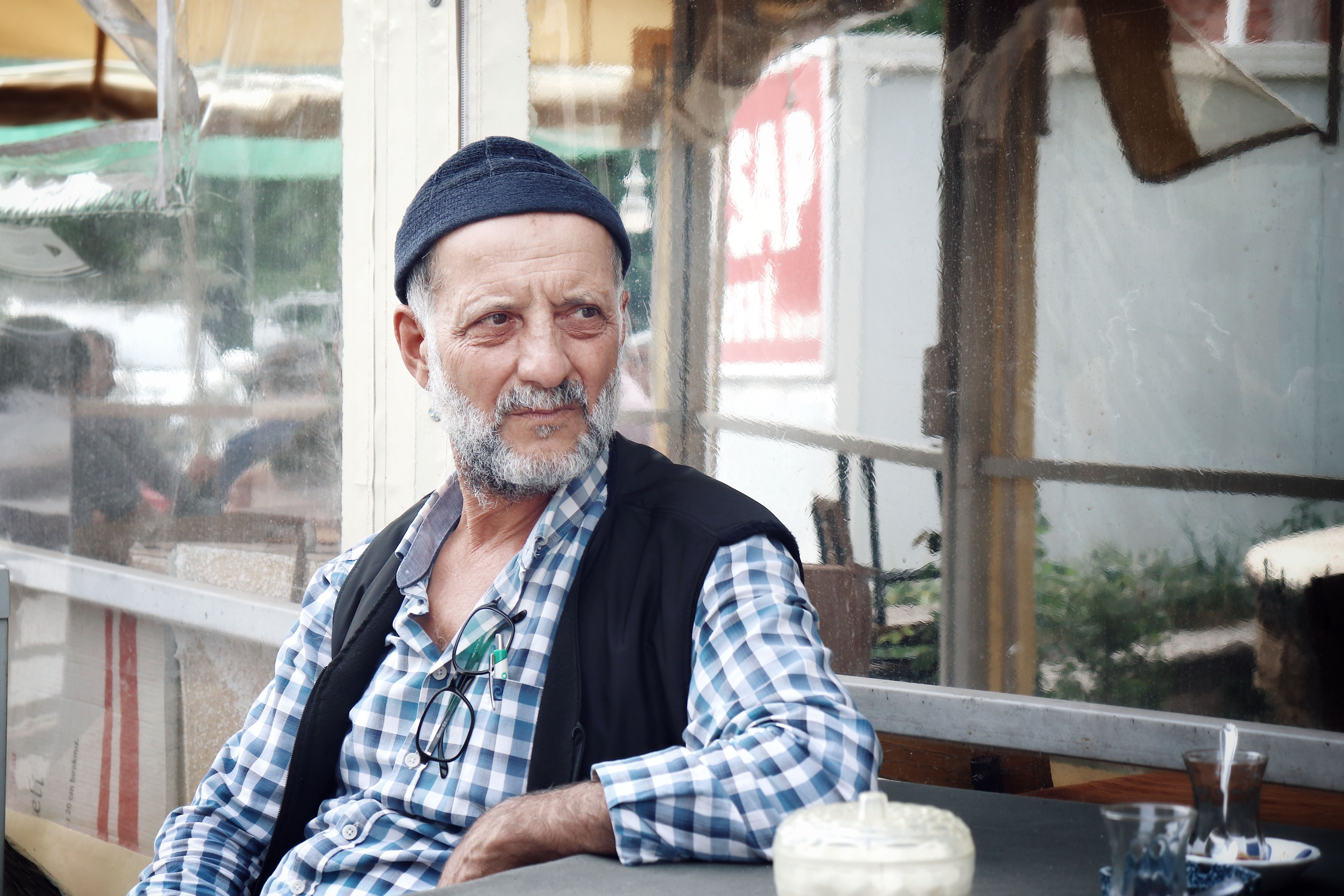 A senior man enjoys a peaceful moment at a café in Malatya, Türkiye.