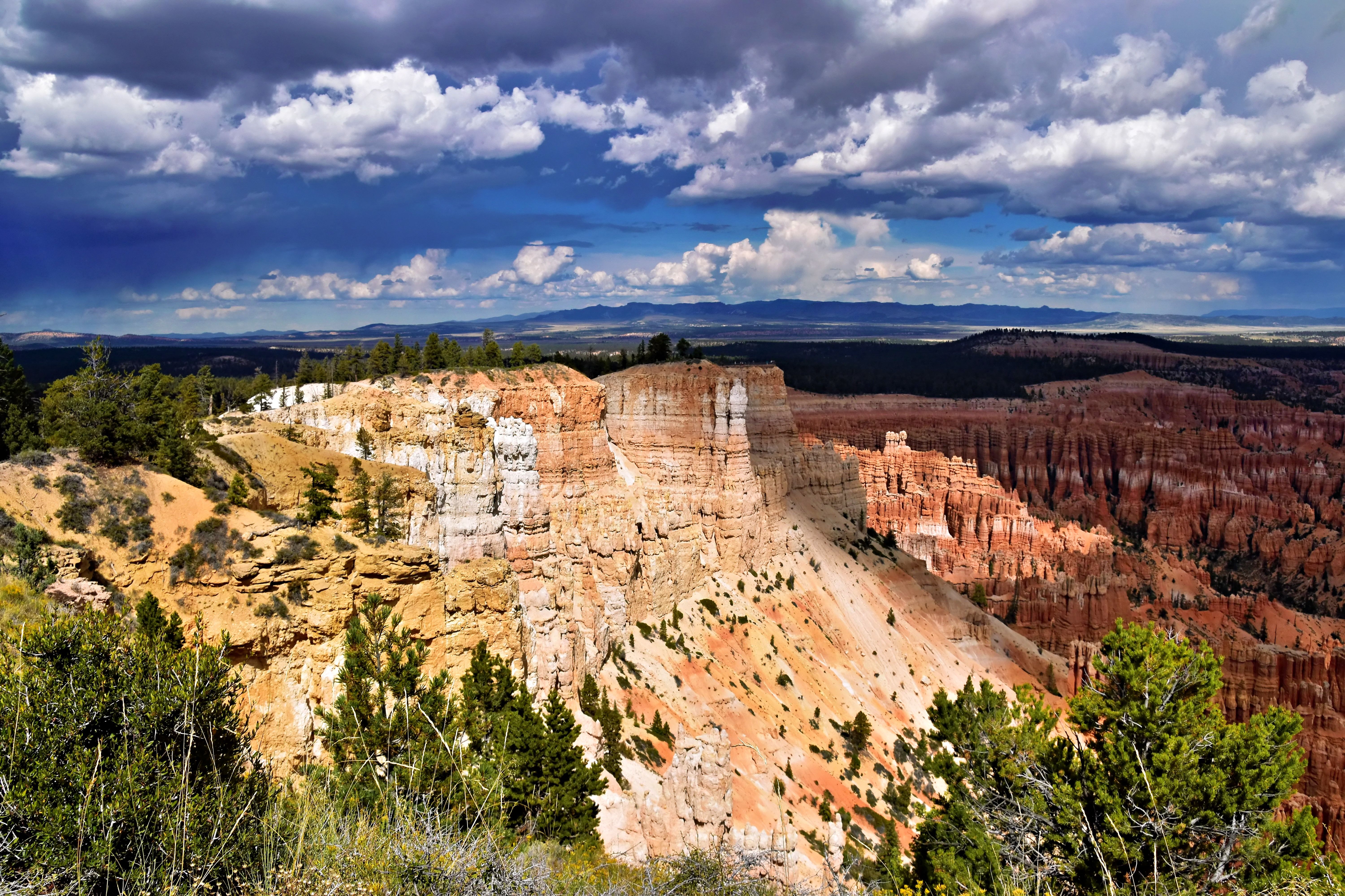 Explore the dramatic rock formations and vibrant colors of Bryce Canyon National Park under a vast sky. - Bryce Canyon
