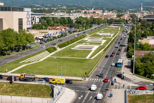 Free A bustling intersection in Zagreb, Croatia, showing city traffic against a green park backdrop. Stock Photo